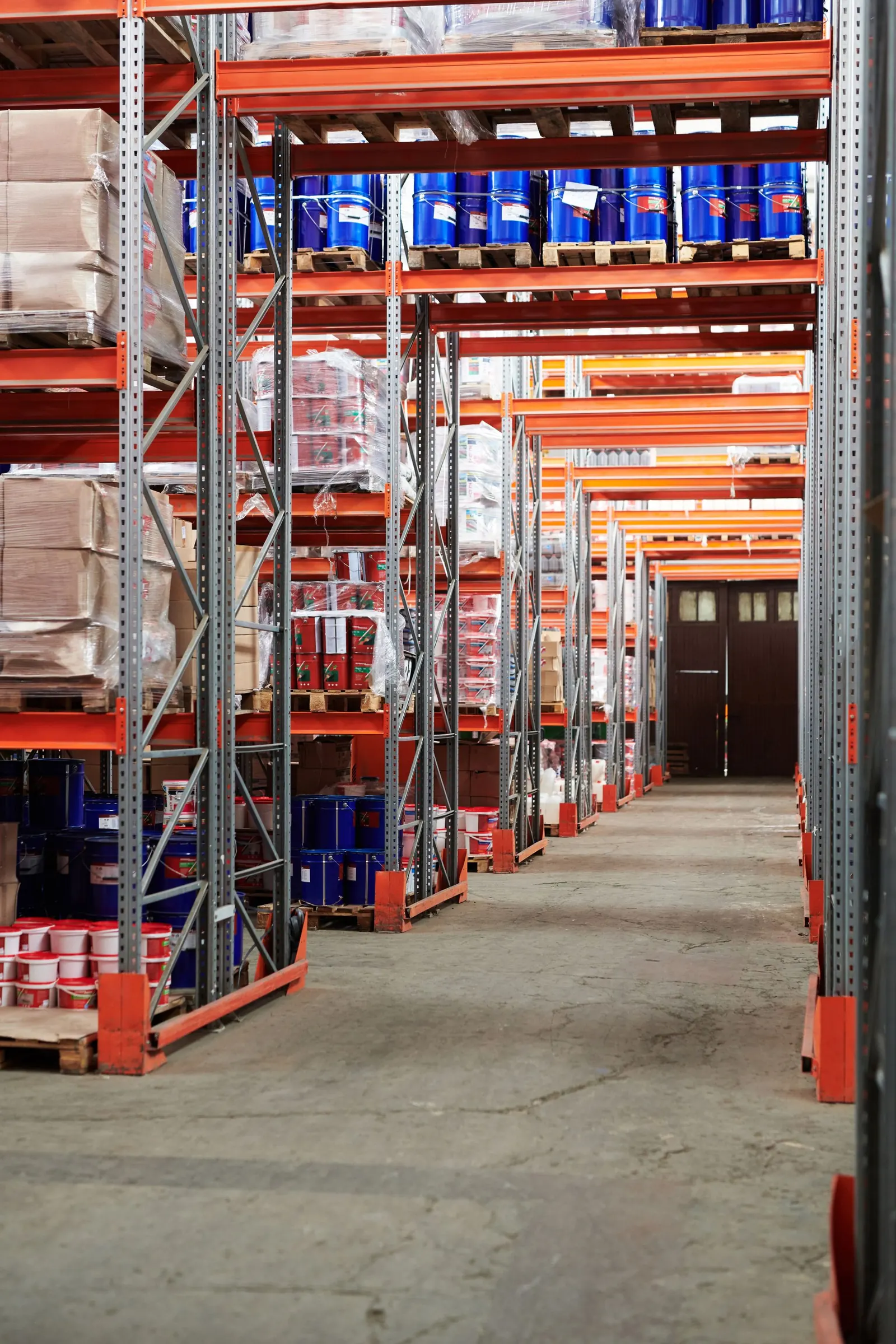 Warehouse aisle with pallet racking over an industrial concrete floor.